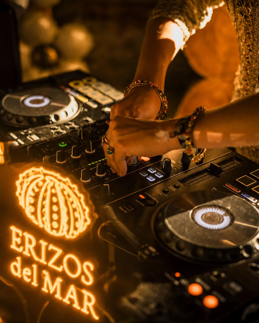 Sesión de DJ junto al neón de Erizos del Mar durante una noche en el restaurante