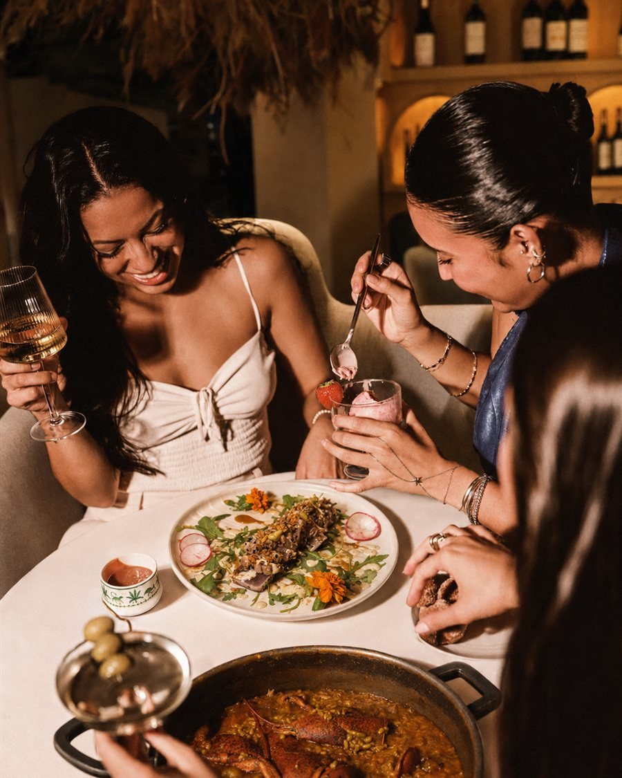 Clientas compartiendo tataki, postre y un arroz con bogavante en la mesa del restaurante